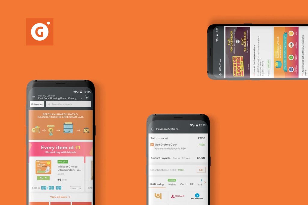 three smartphones opened grofers app in an orange background