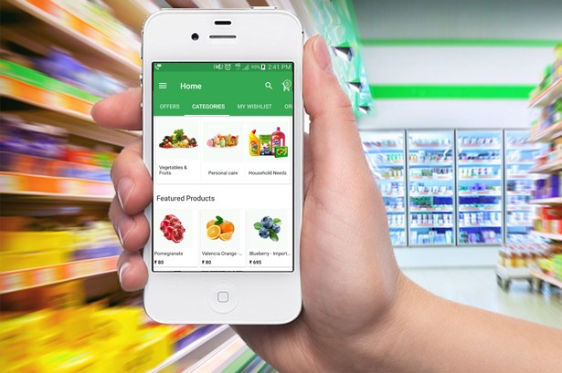 a person holding an iphone with mi grocery app